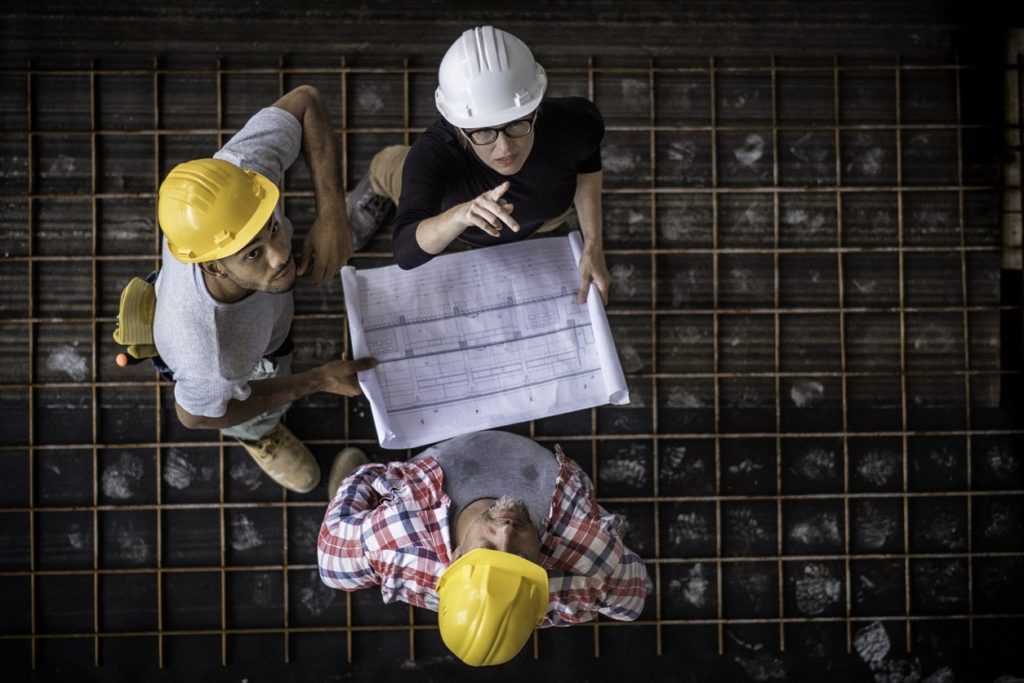 Businesswoman talking to building inspectors about conducting routine check up of her property.